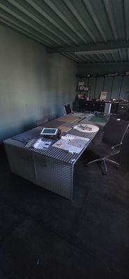 a desk with a chair and a laptop on it in a room