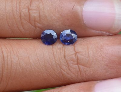 quelqu'un tient dans sa main une paire de saphirs bleus