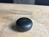 un gros plan sur un petit objet noir posé sur une table en bois