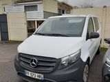 une camionnette blanche garée sur un parking à côté d'une voiture noire