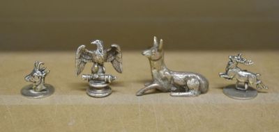 four silver figurines of animals on a table