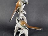 two figurines of birds sitting on top of each other