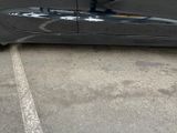 a black car parked in a parking lot next to a building