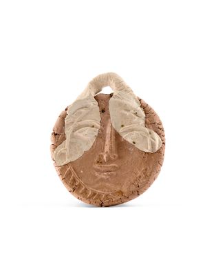 une image représentant une sculpture du visage d'une femme sur un morceau de liège