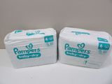 two packs of pampers baby dry diapers sitting on top of each other