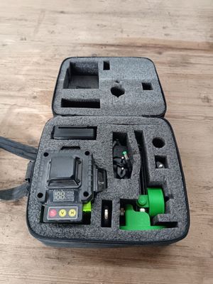 une mallette noire avec une poignée verte posée sur une table en bois