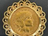 gros plan d'une pièce d'or portant un visage de femme