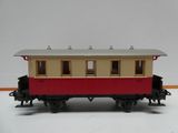 un petit wagon rouge et beige posé sur un fond blanc