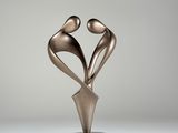 une sculpture en bronze représentant deux personnes se tenant la main, posée sur un socle noir