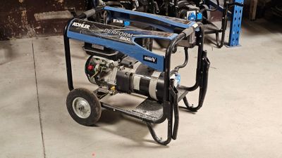 un petit générateur bleu posé sur un chariot dans un garage