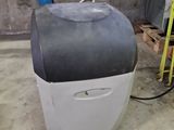 a white and black cooler sitting in a garage