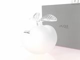 une pomme blanche avec une feuille dessus, à côté d'une boîte