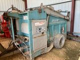 un camion-benne bleu qui est garé dans la poussière