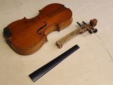 un violon posé sur une table à côté d'un morceau de bois