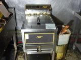 une photo d'une cuisine sale avec une cuisinière et une poubelle
