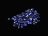 some blue crystals are scattered on a black surface