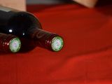 two bottles of wine sitting on a red cloth