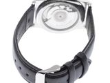 a close up of a watch on a white surface