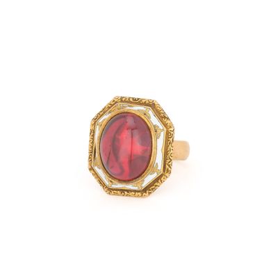 gros plan d'une bague en or avec une pierre rouge