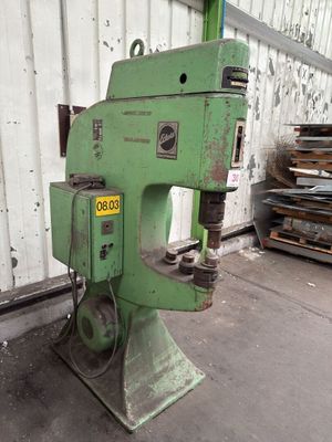 a green machine that is sitting in front of a building
