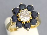 une bague en or sertie d'un diamant blanc et de saphirs bleus