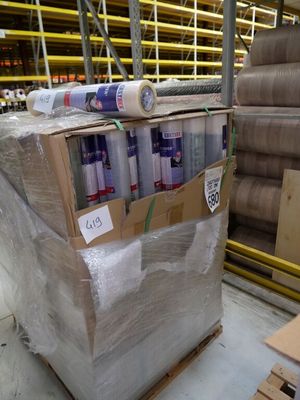 de nombreux rouleaux de papier sur une palette dans un entrepôt