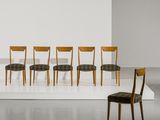six chaises dans une pièce au sol blanc et aux murs blancs