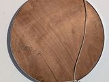 a picture of a round wooden object hanging on a wall