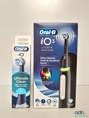 une boîte de brosses à dents posée à côté d'un tube de dentifrice