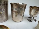 a silver vase and other silver objects on a table