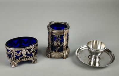 three pieces of silver and blue glass are sitting on a table