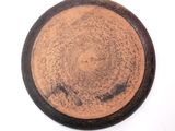 a brown plate with a black rim on a white surface
