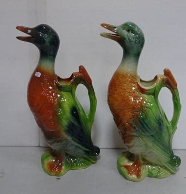 two ceramic ducks that are standing next to each other