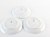 three white plates with blue and white designs on them sitting on a white surface