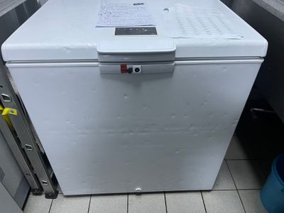 un petit réfrigérateur blanc dans le coin d'une cuisine