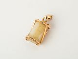 a gold plated pendant with a rectangular glass pendant on a white background