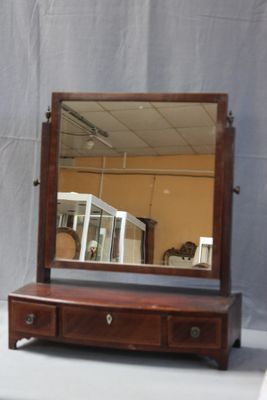 a mirror sitting on top of a dresser next to a mirror