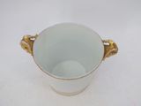 a white cup with gold handles sitting on a table
