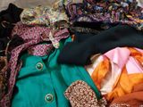 a pile of clothes that is sitting on a bed