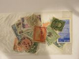 de nombreux timbres différents dans un sachet transparent posé sur une table