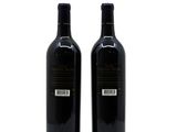 two bottles of wine sitting next to each other on a white surface