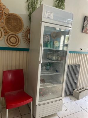 a red chair sitting in front of a white refrigerator