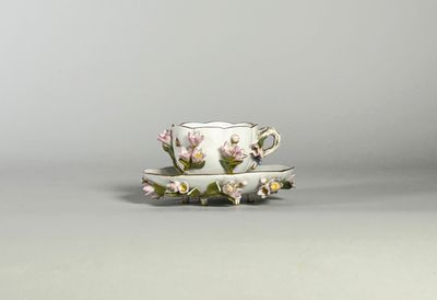 tasse à thé et soucoupe ornées de fleurs roses sur fond gris