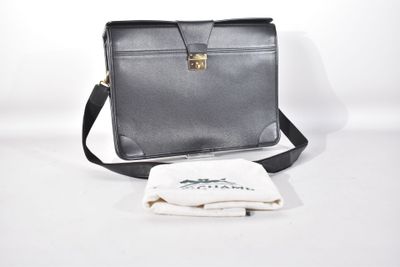 un sac noir et une serviette blanche posés sur une table