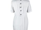 the dress is white and has buttons on the front