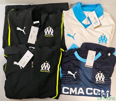 trois maillots et shorts de football pour homme posés sur une table