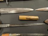 many different types of knives on display on a table