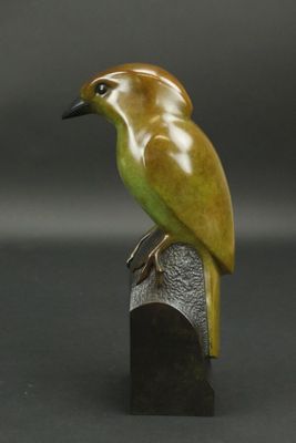 statue représentant un oiseau perché sur un morceau de bois