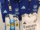 Plusieurs maillots de football sont alignés sur une surface blanche