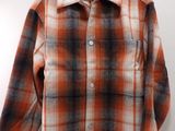a close up of a shirt on a hanger on a wall